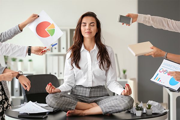 Businesswoman with a lot of work to do meditating in office
